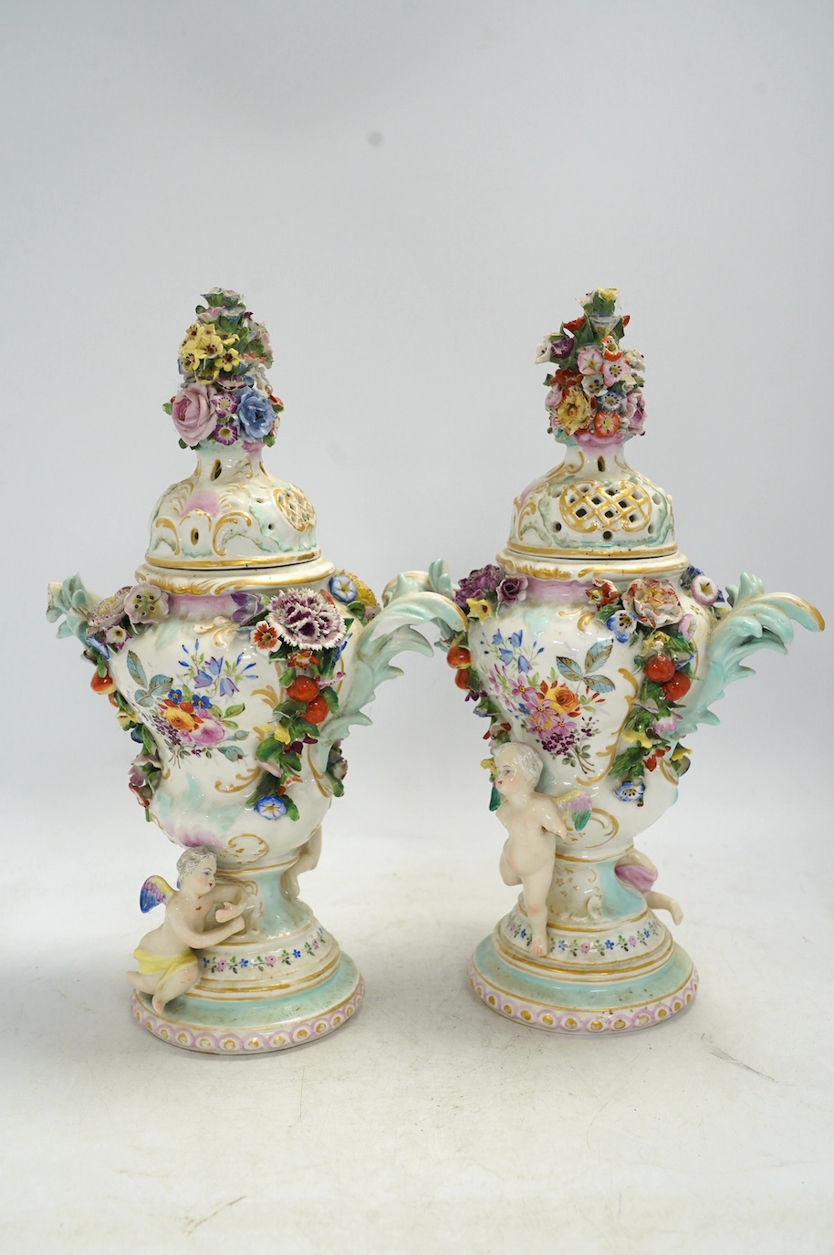 A pair of Potschappel porcelain floral encrusted vases and covers, 31cm high. Condition - poor